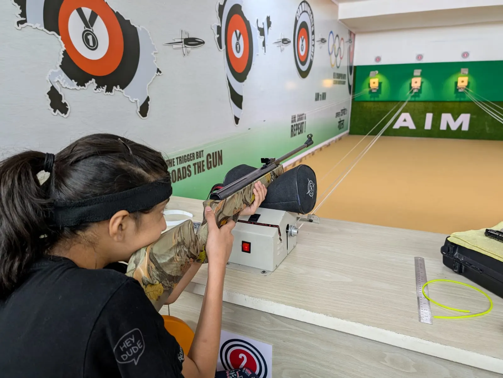 Young shooter aiming a 10m air rifle at the target bays